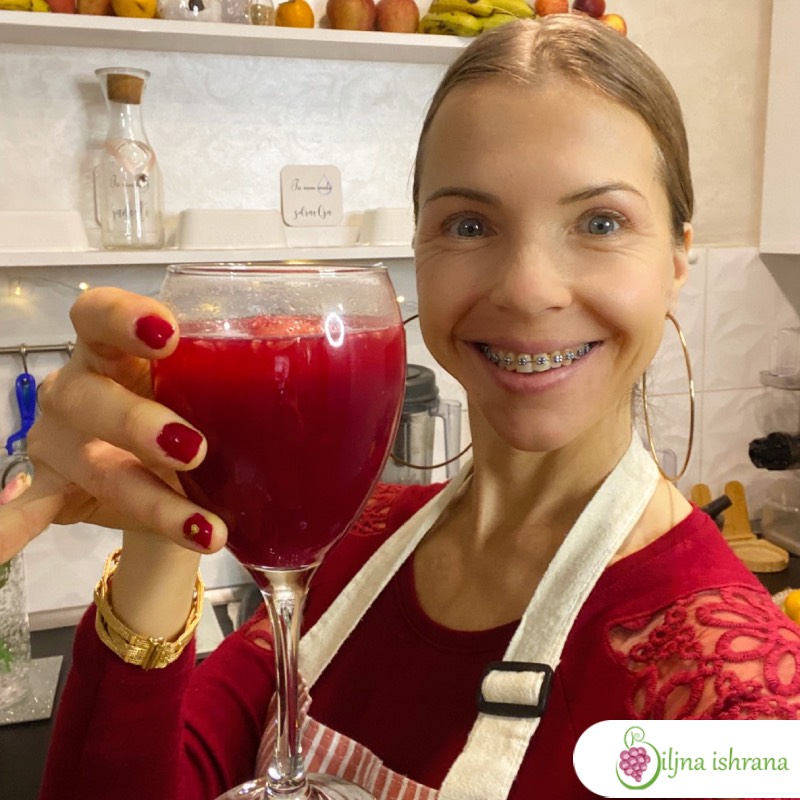 Marina sa Biljne ishrane drži vinsku čašu punu soka od nara i smeje se.