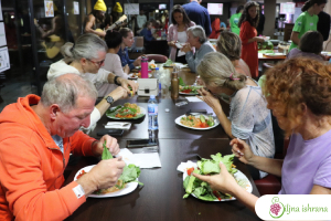 Učesnici uživaju u sirovoj veganskoj večeri na 'Jadranskom festivalu voća', oktobar 2022. u Ulcinju, Crna Gora. Na 'Palićkom festivalu voća' učesnici uče u teoriji i praksi da se hrane sirovom biljnom hranom, vežbaju svakodnevno i održe visok stepen zdravlja dugoročno kroz zdrav način života.