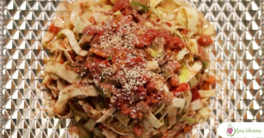 Sirova veganska pasta taljatele u bologneze sosu na tanjiru slikana od gore.