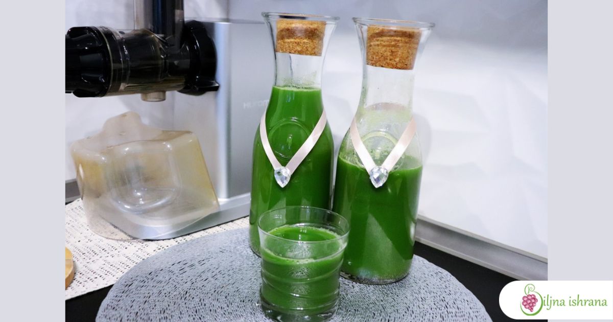 Sokovnik 'Hurom' stoji na kuhinjskom pultu iza dve flaše i jedne čaše pune zelenog soka.