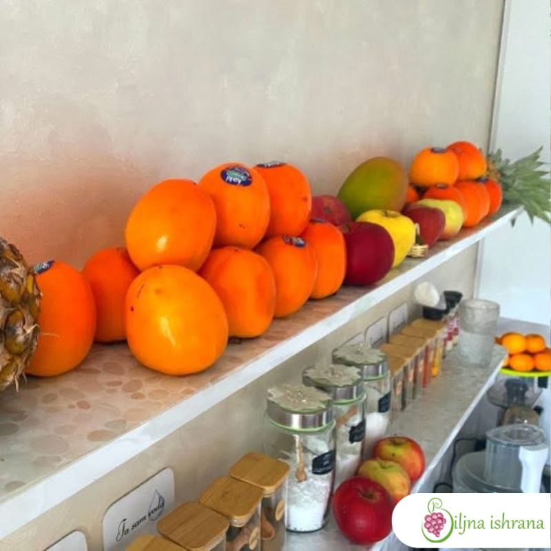 Japanske jabuke poslagane na gomilu na kuhinjskoj polici.