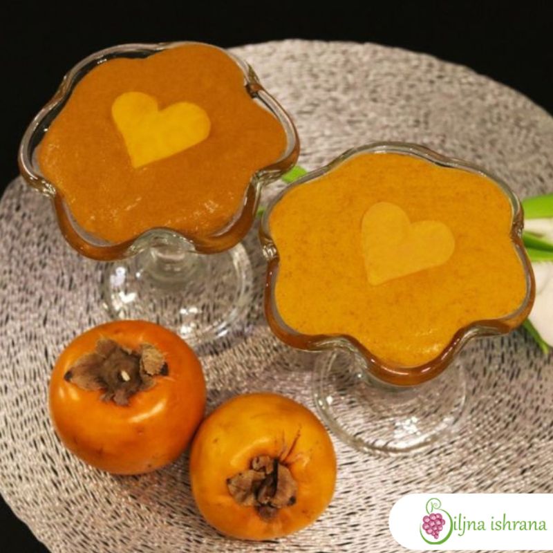 Dve staklene činije za posluživanje pudinga, do vrha napunjene pudingom od japanskih jabuka. Pored činija su dve cele japanske jabuke.